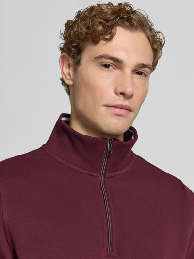 Männermodel trägt Sweatshirt mit Troyer-Kragen von Christian Berg Men in Dunkelrot, Reißverschluss, Baumwoll-Mix, Slim Fit, Nahaufnahme Oberkörper.