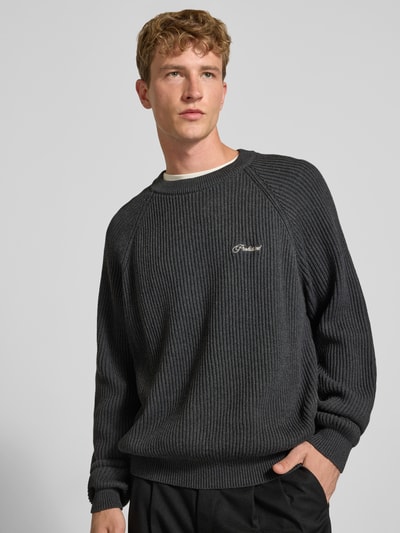 Männermodel trägt Relaxed Fit Strickpullover aus reiner Baumwolle Modell 'Campus' von PROHIBITED, dunkle Farbe, gerippte Textur, Nahaufnahme Oberkörper, Herren Strickpullover, KI-modifiziertes Bild.