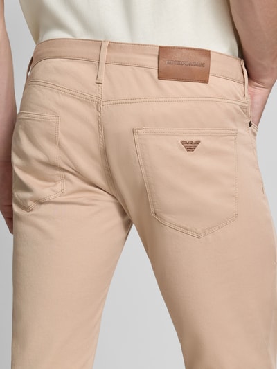 Männermodel trägt Slim Fit Jeans aus Baumwoll-Mix im 5-Pocket-Design von Emporio Armani in Beige, Detailaufnahme Rückansicht. Herren Jeans von Armani, elastischer Baumwoll-Mix, Slim Fit, 5-Pocket-Design, Knopf- und Reißverschluss, Bundweite 43 cm, Innenbeinlänge 82 cm.