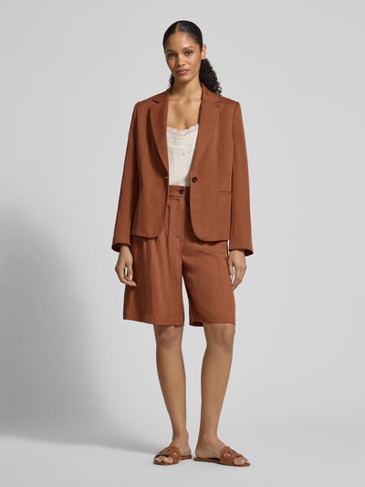 Vrouwenmodel draagt Regular Fit Blazer met paspelzakken van Jake*s collectie in roestbruin, met reverskraag en knoopsluiting, ganzekijk van voren. Ruglengte bij maat 38: 65 cm, borstwijdte bij maat 38: 52 cm, mouwlengte bij maat 38: 43 cm.