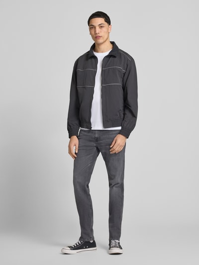 Männermodel trägt Slim Fit Jeans im 5-Pocket-Design Modell 'Anbass' von Replay, Körpernaher-Schnitt, Grau, Ganzkörperansicht von vorne. Bundweite bei Größe 32/32: 43 cm, Innenbeinlänge: 83 cm, Knopf-Reißverschluss.