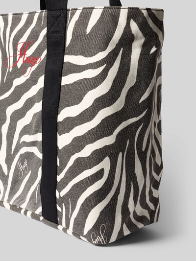 Produktfoto, Shopper aus reiner Baumwolle Modell 'BECKY ZE_TOTE' von HUGO mit Optik:Allover-Muster im Animal-Muster, Label-Print, rechteckig, Tragehenkel, Aufteilung: Hauptfach, Reißverschlussfach, weiße und schwarze Farben, strukturierte Textur.
