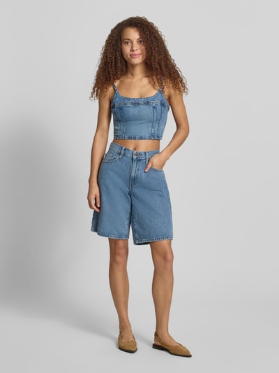 Vrouwenmodel draagt Loose Fit Jeansshorts uit puur katoen model 'MIDDY JORT' van Levi's®, denimlook, 5-pocketmodel, labelpatch, riemlussen, knoop- en ritssluiting, vooraanzicht volledige lichaamsopname.