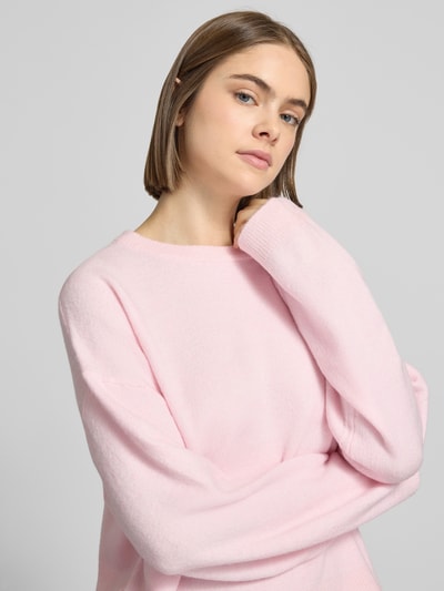 Frauenmodel trägt Relaxed Fit Strickpullover mit Crew Neck Modell 'SIMONI' von Only in Rosa, melierte Optik, Nahaufnahme Oberkörper.