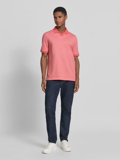 Männermodel trägt Regular Fit Poloshirt aus Baumwolle mit V-Ausschnitt von MAERZ Muenchen in Rosa mit Label-Detail, Ganzkörperansicht von vorne. Rückenlänge bei Größe 50: 71 cm.