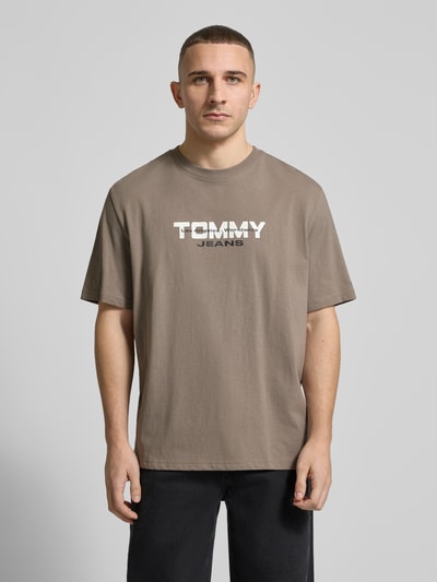 Männermodel trägt Regular Fit T-Shirt aus reiner Baumwolle von Tommy Jeans in Unifarbe, Label-Schriftzug, Rundhals, Ganzkörperansicht von vorne.