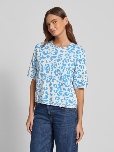 Frauenmodel trägt Relaxed Fit Shirt aus Viskose-Anteil Modell 'Mayas' von Vila mit Allover-Animal-Print, Strick-Optik, Halbarm, Ganzkörperansicht von vorne.
