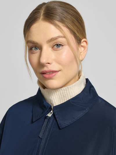 Frauenmodel trägt Jacke mit Pattentaschen Modell 'CICAMI' von CINQUE in Dunkelblau, glatte Textur, Nahaufnahme Oberkörper, Regular Fit, Umlegekragen, sichtbarer Reißverschluss.
