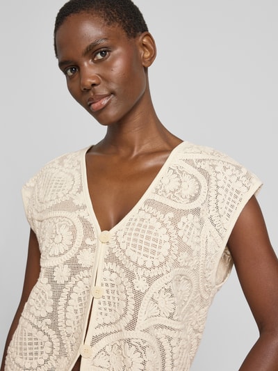 Frauenmodel trägt Strickweste mit V-Ausschnitt Modell 'Crossy' von FREE/QUENT aus Reine Baumwolle, Embroidery Design, Nahaufnahme Oberkörper.