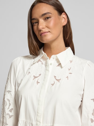 Frauenmodel trägt knielanges Hemdblusenkleid mit Lochstickerei Modell 'Zimia' von YAS aus Reine Baumwolle, tailliert, Langärmelig, Umlegekragen, durchgehende Knopfleiste, Brustweite 51 cm, Rückenlänge 92 cm, fein strukturierte Textur, Nahaufnahme Oberkörper.