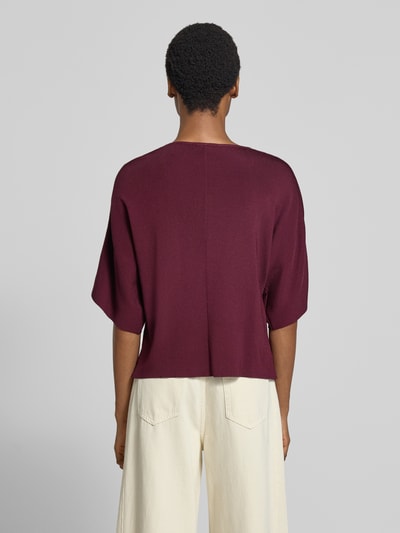 Frauenmodel trägt Relaxed Fit Cardigan aus Viskose-Mix in Strick-Optik von MORE & MORE in dunklem Weinrot, Ganzkörperansicht Rückansicht.