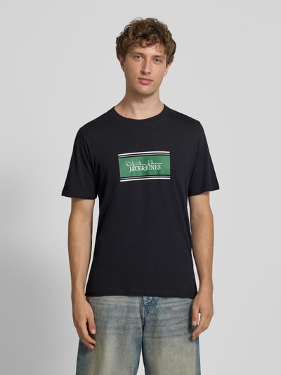 Männermodel trägt Regular Fit T-Shirt mit Logo-Print Modell 'Buster' von JACK & JONES, Schwarz, reine Baumwolle, Ganzkörperansicht von vorne.