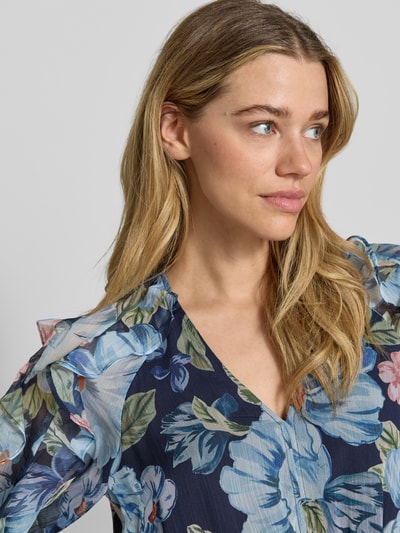 Vrouwenmodel draagt Maxikleid mit Rüschen und Knopfleiste van Oui in blauw met bloemendessin, V-hals, ruche, knoopsluiting, mouwen met ruches, volantzoom, getailleerd model, detailopname bovenlichaam.