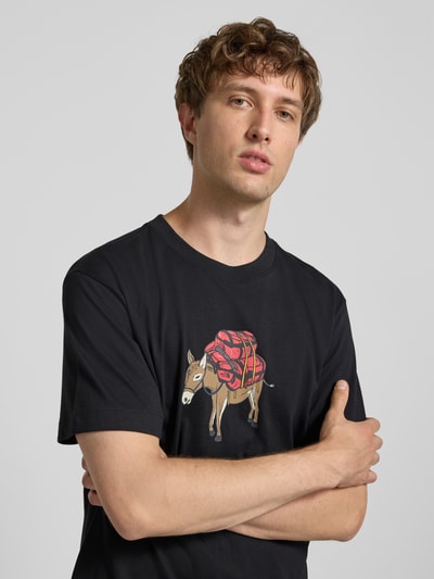 Mannelijk model draagt t-shirt Model 'DONKEY TAXI' van The North Face, zwart met motiefprint, puur katoen, regular fit, ronde hals, Nahaufnahme Oberkörper.