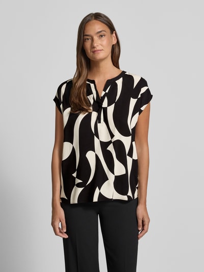 Frauenmodel trägt Regular Fit Bluse aus Viskose mit V-Ausschnitt Modell 'CHANISE' von Soyaconcept, Schwarz-Weiß Muster, Nahaufnahme Oberkörper. Rückenlänge bei Größe S: 65 cm, Allover-Look.