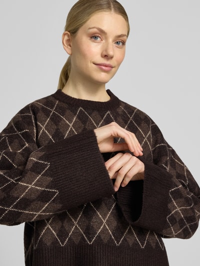 Vrouwenmodel draagt Relaxed Fit pullover met wol van Neo Noir, elastische materiaalmix, tricotlook, ronde hals, detailopname bovenlichaam.