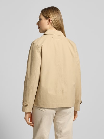 Frauenmodel trägt Jacke mit Eingrifftaschen und Ärmelriegeln von Gant in Beige, Baumwoll-Mix, lockerer Schnitt, Rückansicht, Ganzkörperansicht.