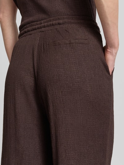 Frauenmodel trägt Wide Fit Stoffhose mit Strukturmuster Modell 'Mileni' von OPUS im Elastischer-Material-Mix, Detailaufnahme Rückenansicht.