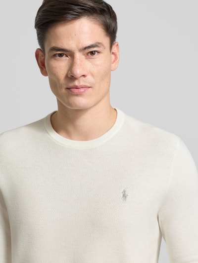 Męskimodel nosi Sweter z dzianiny z wyhaftowanym logo od Polo Ralph Lauren, bawełna, krój regular fit, prążkowane wykończenia, okrągły dekolt, kolor jasny, tekstura gładka; Nahaufnahme Oberkörper.