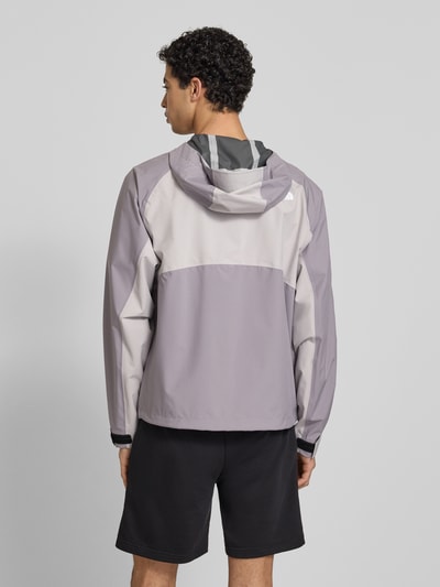 Männermodel trägt Regenjacke mit Logo von The North Face in Grau und Violett, Regular Fit, Kapuze, Reißverschluss, Rückenansicht, Rückenlänge bei Größe M 70 cm, Schulterbreite 50 cm, Brustweite 62 cm, Ärmellänge 76 cm.