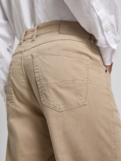 Männermodel trägt Regular Fit Jeans mit Eingrifftaschen von bugatti aus Baumwoll-Mix mit Stretch-Anteil, Detailaufnahme Rückansicht.