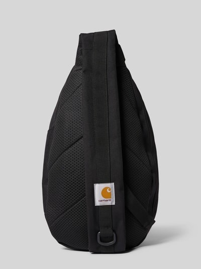Produktfoto, schwarze Sling Bag mit Logo-Patch Modell 'Kyle' von Carhartt Work In Progress, grob strukturierte Oberfläche, Hauptfach mit Reißverschluss, verstellbarer Schulterriemen, Tunnelzug, kompakte Form, Rechteck Maße 20x35x10 cm, Schulterriemen 90 cm