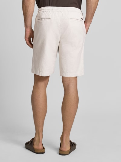Männermodel trägt Bermudas mit französischen Eingrifftaschen Modell 'COLI' von Fynch-Hatton in Beige, Baumwoll-Mix mit Leinen-Anteil, Loose-Fit, elastischer Bund mit Kordelzug, Gesäßleistentaschen, Innenbeinlänge ca. 22 cm, Ganzkörperansicht Rückansicht.