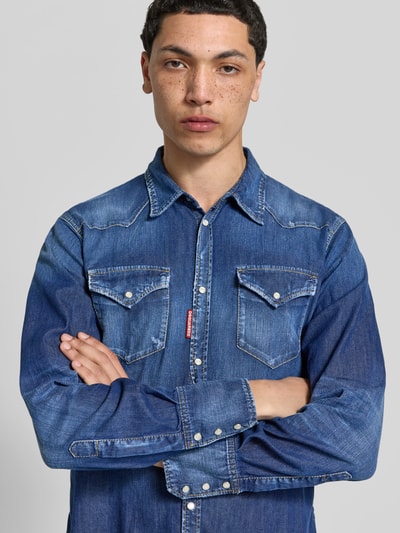 Männermodel trägt Classic Fit Jeanshemd aus Baumwoll-Mix von Dsquared2 in Dunkelblau mit Kentkragen, durchgehende Knopfleiste, Nahaufnahme Oberkörper. Rückenlänge 77 cm, Schulterbreite 44 cm, Ärmellänge 67 cm.