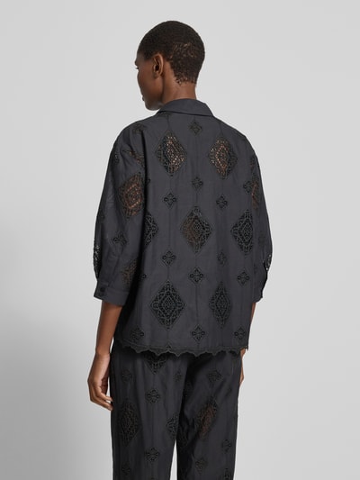 Frauenmodel trägt Regular Fit Bluse mit Häkelspitze Modell 'MURIEL' von Bash in Schwarz, mit Hemdblusenkragen, verdeckter Knopfleiste und 3/4-Arm, Rückenlänge 65 cm, 40 cm Ärmellänge, Muster aus Spitzendetails, Ganzkörperansicht Rückansicht.