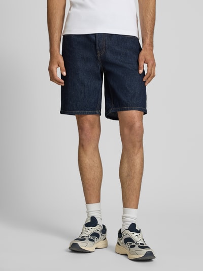 Männermodel trägt Regular Fit Jeansshorts aus reiner Baumwolle Modell 'EDGE' von Only & Sons in Denim-Optik, Materialverarbeitung Twill, 5-Pocket-Design, Label Patch, Knopf und verdeckte Knopfleiste, Gürtelschlaufen, Ganzkörperansicht von vorne.