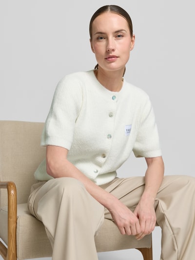 Frauenmodel trägt Regular Fit Strickjacke aus Viskose-Mix Modell 'MONA' von VILLA SOPHIE, Optik: Unifarben, Stricktextur, Label-Applikation, Rundhals, Kurzarm, gerippte Abschlüsse, Ganzkörperansicht von vorne.