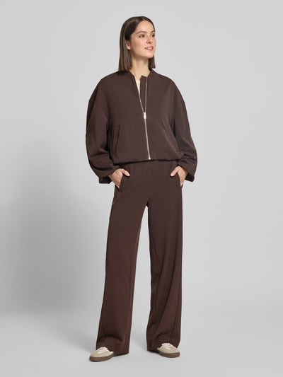 Modelka kobieca ma na sobie Hose mit elastischem Bund Modell 'Melane flow' od OPUS z materiału z domieszką wiskozy, krój regular fit, kolor ciemnobrązowy, Szerokość w rozmiarze 36: 39 cm, Długość wewnętrzna nogawki w rozmiarze 36: 81 cm, tekstura gładka, widok całej sylwetki z przodu