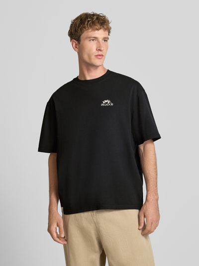 Männermodel trägt Oversized T-Shirt mit Backprint von PEGADOR in Schwarz aus reiner Baumwolle, Rundhalsausschnitt, Nahaufnahme Oberkörper.