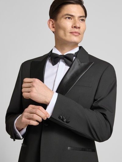 Männermodel trägt 1-Knopf-Smoking-Sakko mit Reverskragen von Christian Berg Men, schwarz, Material-Mix mit Viskose-Anteil, Regular-Fit, Knopfverschluss, Brusttasche, Eingrifftaschen, Nahaufnahme Oberkörper.