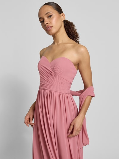 Frauenmodel trägt Maxikleid im Off-Shoulder-Look von Mascara in Altrosa, Chiffon, taillierter Schnitt, Nahaufnahme Oberkörper.