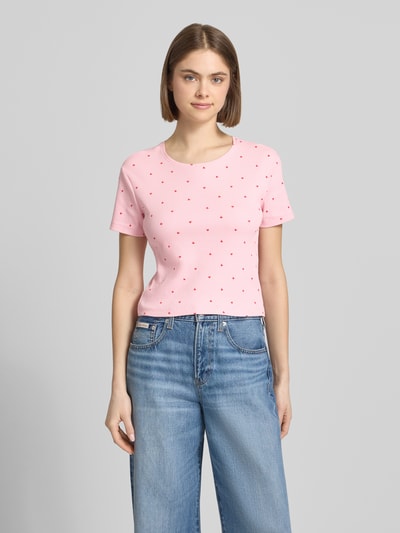Frauenmodel trägt Damen T-Shirt von Only, Modell 'FENJA', Optik:Allover-Muster, Motiv-Print, Regular-Fit, Rundhals, Kurzarm, Feinripp, Baumwoll-Mix, zartrosa mit kleinen roten Motiven, glatte Struktur, Ganzkörperansicht von vorne.