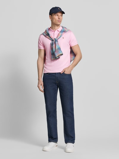 Männermodel trägt Regular Fit Poloshirt aus reiner Baumwolle von Polo Ralph Lauren in Optik: Unifarben mit Logo-Stitching, Ganzkörperansicht von vorne.
