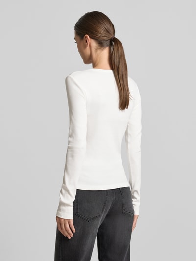 Frauenmodel trägt weißes Slim Fit Langarmshirt aus Baumwoll-Mix Modell 'CHLOE' von VERO MODA, dezente Struktur, Ganzkörperansicht Rückansicht.
