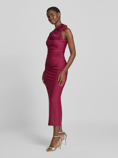 Frauenmodel trägt Cocktailkleid mit floralen Applikationen Modell 'DONA' von YAS in Satin, bordeauxrot, körpernah, Midilänge, Ganzkörperansicht von vorne.