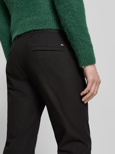 Männermodel trägt Straight Leg Hose aus atmungsaktivem Material Modell 'DENTON' von Tommy Hilfiger, Optik: Unifarben, Gesäßtaschen, Ganzkörperansicht Rückansicht.