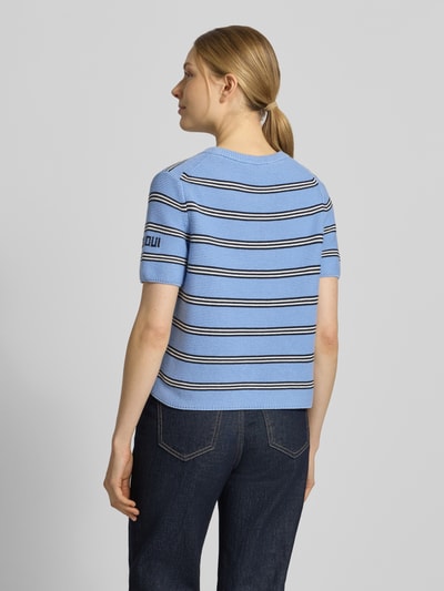Vrouwenmodel draagt Strickshirt met florale appliqué van Oui, regular fit, puur katoen, ronde hals, blauw met streepmotief, achteraanzicht volledige lichaamsopname.