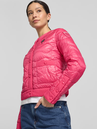 Kobiece model prezentuje kurtka pikowana Steppjacke mit Label-Detail Modell 'HADLEY' od Blauer Usa w wyrazistym różowym kolorze, krój slim fit, okrągły dekolt, listwa guzikowa, wpuszczane kieszenie, detal z logo; długość tyłu w rozmiarze S: 49 cm, szerokość ramion w rozmiarze S: 40 cm, szerokość klatki piersiowej w rozmiarze S: 47 cm, długość rękawów w rozmiarze S: 62 cm; całkowity widok z przodu.
