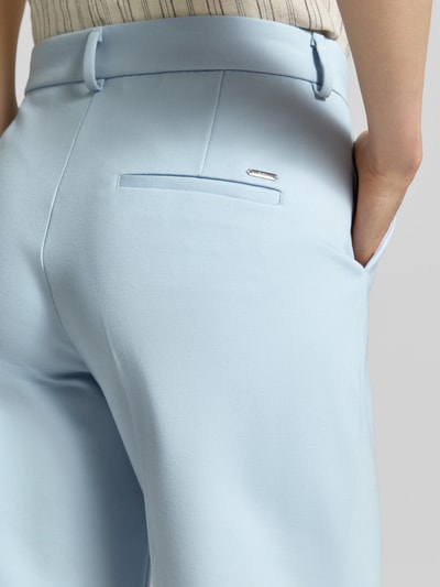 Kobiece model prezentuje spodnie z szerokimi nogawkami Wide Leg Hose aus Viskose-Mix od Brax, efekt: jednolity kolor, aplikacja z marką, szlufki na pasek, zapięcie na guzik i zamek błyskawiczny, wpuszczane kieszenie boczne, lamowana kieszeń z tyłu, mieszanka wiskozy, zbliżenie na tył