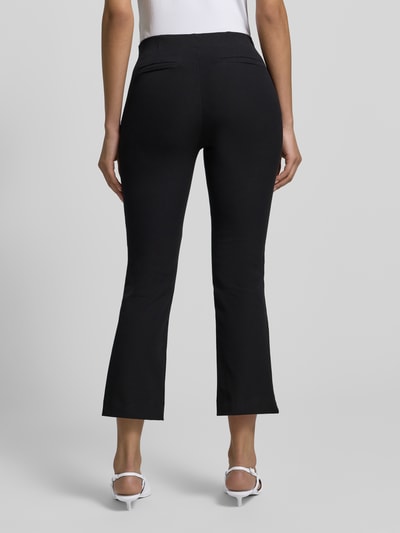 Frauenmodel trägt Flared Stoffhose mit Nahtreißverschluss von Jake*s Collection in Schwarz mit Gesäßtaschen, Ganzkörperansicht Rückansicht.