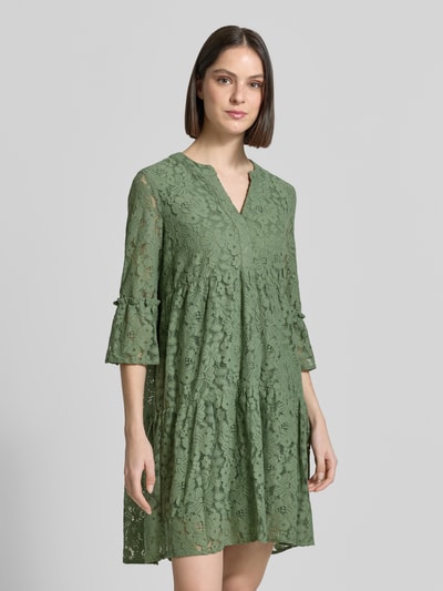 Frauenmodel trägt Loose Fit Spitzenkleid aus Baumwoll-Mix Modell 'HONEY' von Vero Moda, unifarben, grün, Spitzenmuster, Ganzkörperansicht von vorne.