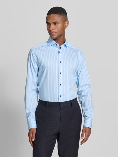 Männermodel trägt Regular Fit Business-Hemd mit Streifenmuster Modell 'Royal Kent' von OLYMP aus reiner Baumwolle, Ganzkörperansicht von vorne.