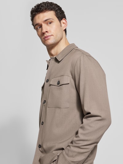Männermodel trägt Relaxed Fit Hemdjacke mit Kentkragen und Brusttaschen von Lindbergh, beige, Material-Mix, Nahaufnahme Oberkörper.