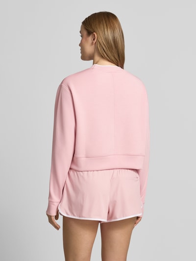 Frauenmodel trägt Cropped Sweatshirt Modell 'tasmin' von VARLEY in Rosa mit Modal-Mix, Stretch-Anteil, Rundhalsausschnitt, Ganzkörperansicht Rückansicht.