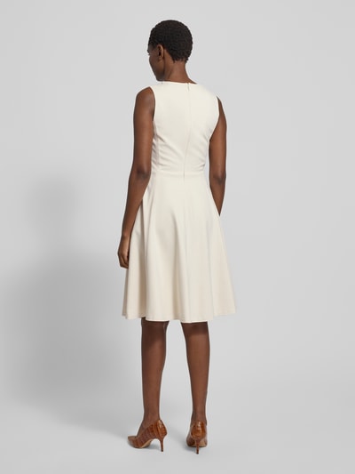 Modelka kobieca nosi kremową sukienkę za kolano z mieszanki wiskozy, fason A-linia, okrągły dekolt, Knielanges Kleid aus Viskose-Mix Modell 'CHARLEY' von Lauren Ralph Lauren, widok całej sylwetki z tyłu.