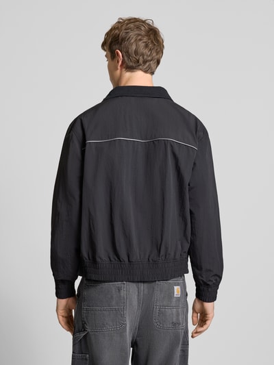 Männermodel trägt Regular Fit Blouson mit Kontraststreifen Modell 'HEIGHTS PIPPING JACKET' von Levi's®, unifarben, Rückenansicht Gesamtansicht.